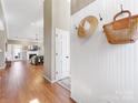 Entryway featuring hardwood floors and wainscoting with coat hooks, flowing into an open living space at 8413 Albury Walk Ln, Charlotte, NC 28277