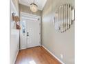 Bright foyer with wood floors, decorative mirror, coat hooks and a modern chandelier, creating a welcoming entrance at 8413 Albury Walk Ln, Charlotte, NC 28277