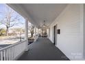 Spacious porch featuring classic white pillars and railings, perfect for outdoor relaxation at 85 Grove Nw Ave, Concord, NC 28025