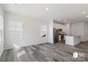 Open-concept living room with hard surface floors leads to a modern kitchen featuring stainless steel appliances at 1211 Pine St # A, Mooresville, NC 28115