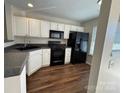 Well-lit kitchen with white cabinetry, and sleek black appliances offer modern appeal at 122 Barnhardt Loop, Mooresville, NC 28117