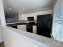 Efficient kitchen featuring white cabinets, black appliances, and ample counter space at 122 Barnhardt Loop, Mooresville, NC 28117