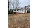 Rear exterior view showing the access stairs, foundation, and small back porch at 122 E Hargrave St # 50, Wadesboro, NC 28170