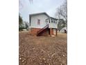 Rear exterior showing the access stairs, foundation, and small back porch at 122 E Hargrave St # 50, Wadesboro, NC 28170