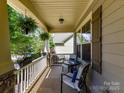 Cozy porch with chairs, table, and hanging plants, perfect for enjoying the outdoors at 16404 Mckee Ridge Dr, Charlotte, NC 28278