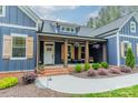 Charming covered porch with wood columns, shutters, seating, and landscaped entryway at 2125 Partridge Berry Ln, Rock Hill, SC 29730