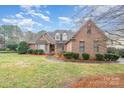 Beautiful brick home featuring manicured landscaping and a well-maintained lawn at 5125 Belicourt Dr, Charlotte, NC 28277
