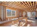 Unfinished living room framed out with exposed ceiling joists and large windows offering natural light at 6230 Old Mocksville Rd, Salisbury, NC 28144