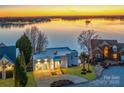 Contemporary home showcasing modern architecture, lush landscaping, and waterfront views at 7111 Anchorage Ln, Tega Cay, SC 29708