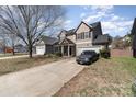 Two-story home featuring a front porch and two-car garage with mature trees and landscaping at 757 Jones Branch Rd, Fort Mill, SC 29715