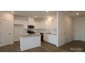 Bright kitchen features white cabinets, stainless appliances, and a granite island at 795 Earhart Nw St, Concord, NC 28027