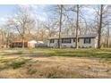Ranch style home with a metal roof surrounded by mature trees on a spacious, well-maintained lawn at 1106 Forest Dr # 75, Marshville, NC 28103