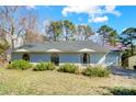 Single-story home with light blue siding, arched windows, well-maintained landscaping, and an attached garage at 1205 Molokai Dr, Tega Cay, SC 29708