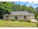 Lovely single-story home with stone accents, arched windows, and a well-manicured lawn surrounded by lush trees at 1205 Molokai Dr, Tega Cay, SC 29708