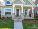 Inviting front porch with brick supports and a modern, covered entryway at 17025 Malone Ln, Mint Hill, NC 28227