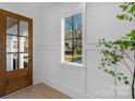 Bright entryway featuring a wooden front door, white walls with molding, and a view to the outside at 302 Marsh Rd, Charlotte, NC 28209