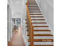 Elegant staircase with wooden steps and white risers, leading to the upper level of the home at 302 Marsh Rd, Charlotte, NC 28209