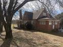 Quaint brick home featuring a covered porch and mature trees at 3045 Woodleaf Rd, Salisbury, NC 28147