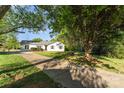 Quaint single-story house with a long driveway and mature trees shading the front yard on a sunny day at 341 Cline Dr, Salisbury, NC 28146
