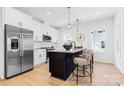 Modern kitchen features a center island with seating, stainless steel appliances, and ample counter space at 3808 Odom Way, Charlotte, NC 28216