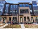 Modern townhome with brick and dark siding, large windows, and well-maintained landscaping at 4010 Citra Ln, Charlotte, NC 28217