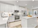 A modern kitchen featuring sleek white cabinets, stainless steel appliances, and quartz countertops at 4010 Citra Ln, Charlotte, NC 28217