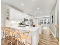 Bright, modern kitchen with white cabinetry, stainless steel appliances, and counter seating flowing into the living space at 4010 Citra Ln, Charlotte, NC 28217