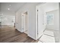 Bright hallway featuring hardwood floors and white doors, leading to various rooms at 4027 Vista Pine Dr, Charlotte, NC 28215