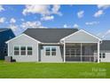 View of the home's rear, featuring a covered patio and a spacious, well-manicured lawn at 9096 El Sworth Dr, Sherrills Ford, NC 28673