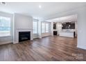 Spacious living room featuring wood floors, fireplace, and open-concept design with kitchen view at 9528 Pointer Rd # 63, Huntersville, NC 28078