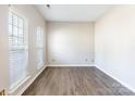 Bright and airy empty room featuring light grey walls, wood-look flooring, and lots of natural light at 1066 Streamlet Way, Monroe, NC 28110