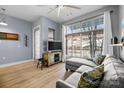 Comfortable living room with large windows, gray sectional sofa, wood floors, and television at 1101 W 1St St # 124, Charlotte, NC 28202