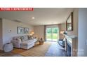 Bright living room features a cozy fireplace and sliding door access to the backyard at 11205 Cardinal Creek Ave, Charlotte, NC 28215