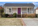 Charming home featuring a covered porch, a purple front door, and nicely maintained landscaping at 114 Glen Rae Sw St, Concord, NC 28025
