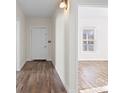 Hallway with wood floors and white walls leading to a light-filled room with a window at 114 Glen Rae Sw St, Concord, NC 28025