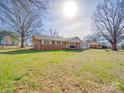 Exterior view of home with a spacious lawn and mature trees on a sunny day at 151 Woodland Sw Dr, Concord, NC 28025