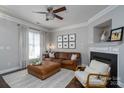 Comfortable living room boasts a fireplace, leather couch, natural light, and a modern ceiling fan at 16619 Spruell St, Huntersville, NC 28078