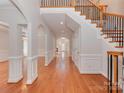 Expansive hallway showcasing hardwood floors, archways, decorative trim, and staircase access at 2100 Winding Oaks Trl, Waxhaw, NC 28173