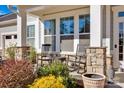 Inviting covered porch with stone pillars, rocking chairs, and colorful landscaping at 2172 Paddlers Cove Dr, Clover, SC 29710