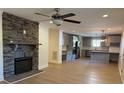 Open living space with a stone fireplace, hardwood floors, and a view of the modern gray kitchen at 3332 Draper Ave, Charlotte, NC 28205