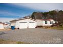 Detached two-car garage with white doors and gravel driveway at 3991 Bunker Hill School Rd, Claremont, NC 28610