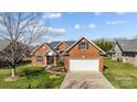 Traditional brick home featuring a well-manicured lawn and a two-car garage at 4405 Zee Ct, Monroe, NC 28110