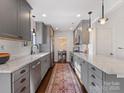 Well-lit kitchen featuring gray cabinets, granite countertops, and stainless steel appliances at 605 Heathermoor Ct, Charlotte, NC 28209
