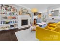 Open-concept living room featuring a fireplace, built-in shelving, and an adjacent kitchen at 605 Heathermoor Ct, Charlotte, NC 28209