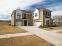 Stunning two-story home boasts a brick and siding exterior, three-car garage, and a basketball hoop on the long driveway at 611 Yucatan Dr, Waxhaw, NC 28173