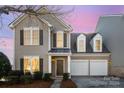 Charming two-story home featuring a welcoming front porch and a well-maintained lawn with mature landscaping at 10142 Linksland Dr, Huntersville, NC 28078