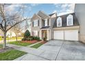 Inviting two-story home with a two-car garage, neat landscaping, and a well-manicured lawn at 10142 Linksland Dr, Huntersville, NC 28078