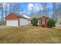 Charming brick home with an attached garage and verdant, professionally landscaped front yard at 1275 Rocky Ridge Trl, Salisbury, NC 28146