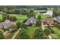 Aerial view showcases a well-manicured lawn and lush landscaping surrounding a grand estate on the golf course at 145 Milford Cir, Mooresville, NC 28117