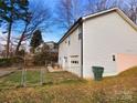 Back of house view showing walkout basement access, chain link fence and green trash can at 1545 Player Ct, Gastonia, NC 28054